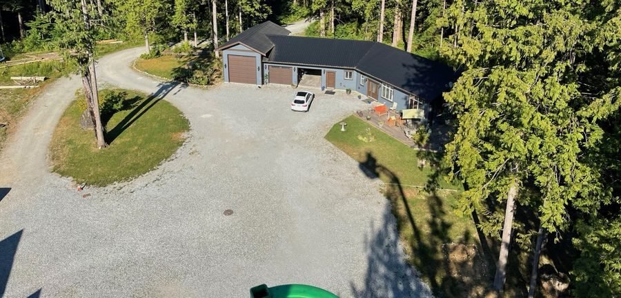 Aerial view of a curved gravel driveway leading to a home
