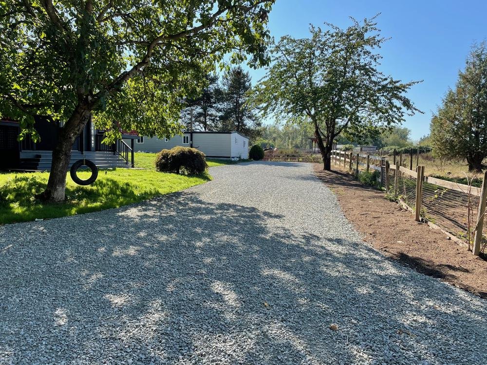 New crushed rock driveway crowned and graded past a house in Hayden, Idaho