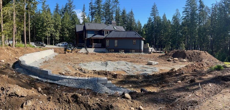 Curved segmental block retaining wall around a home site