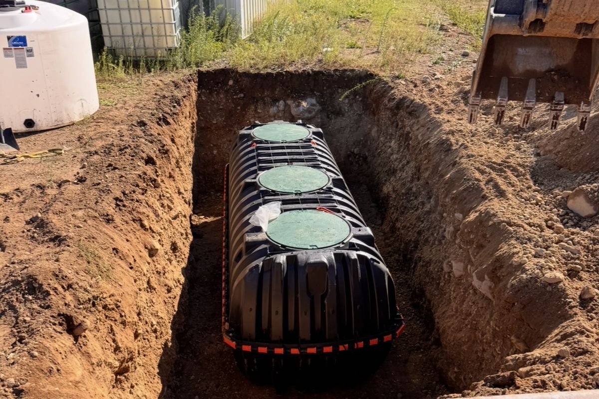 Three-compartment poly septic tank set in an excavated trench on a North Idaho property