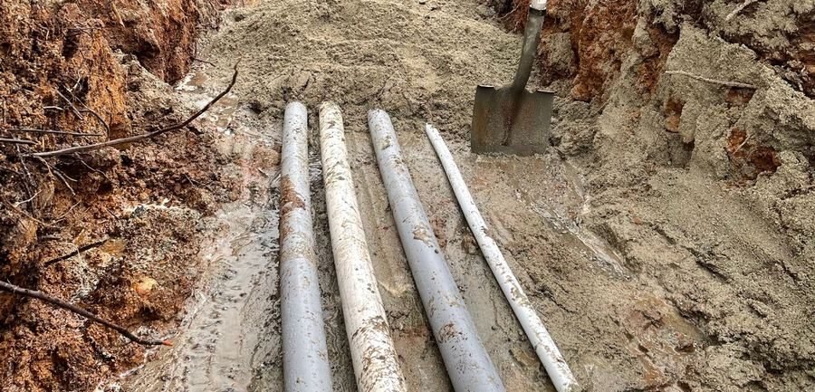 Utility trenching with pipe laid in a dirt trench